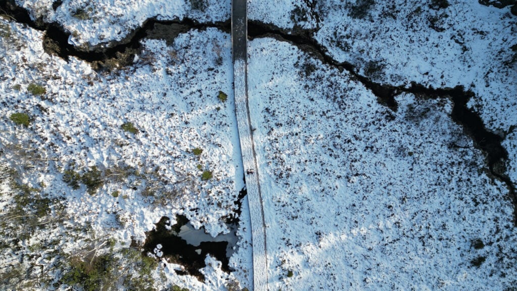 Dronebilde av snødekt tursti og bekk i vinterlandskap nær Lysefjorden og Preikestolen