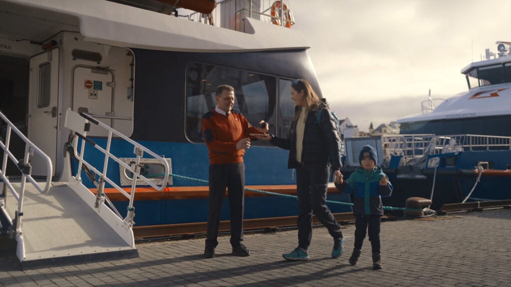 Rødne crew welcoming a family with a child before boarding a fjord cruise boat fjord to Lysefjord
