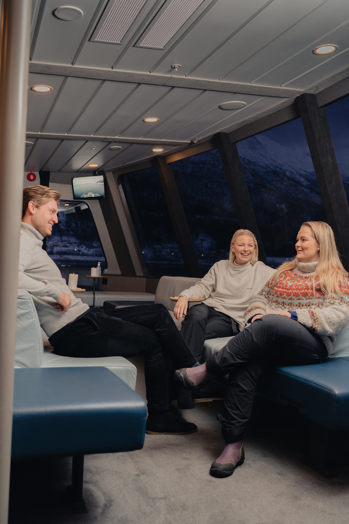 Guest enjoying their time in the boat cabin on a Northern lights cruise.