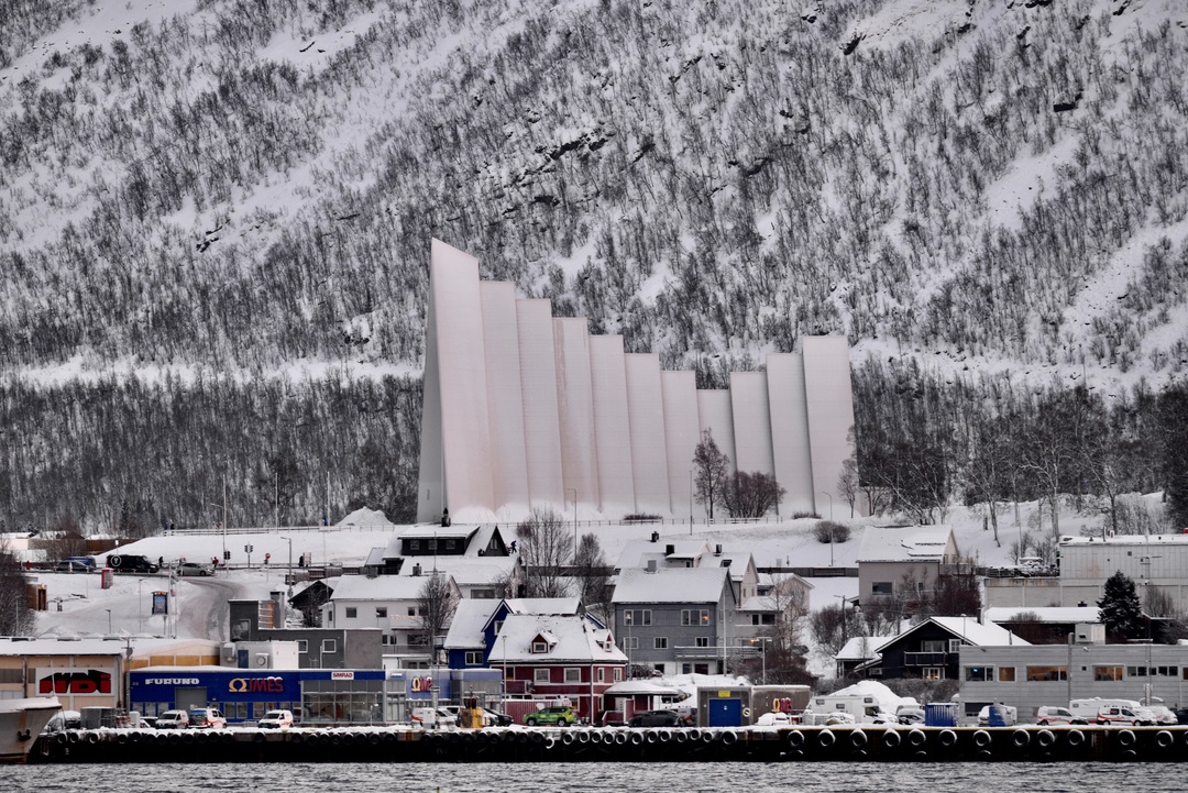 Den majestetiske Ishavskatedralen i Tromsø, sett fra fjorden under et fjordcruise.