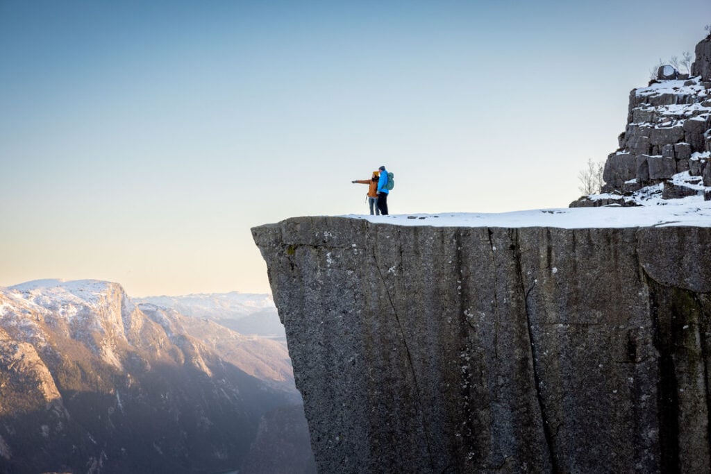 Winter hiking at Preikestolen with views over the Lysefjord in a quiet, snow-covered landscape