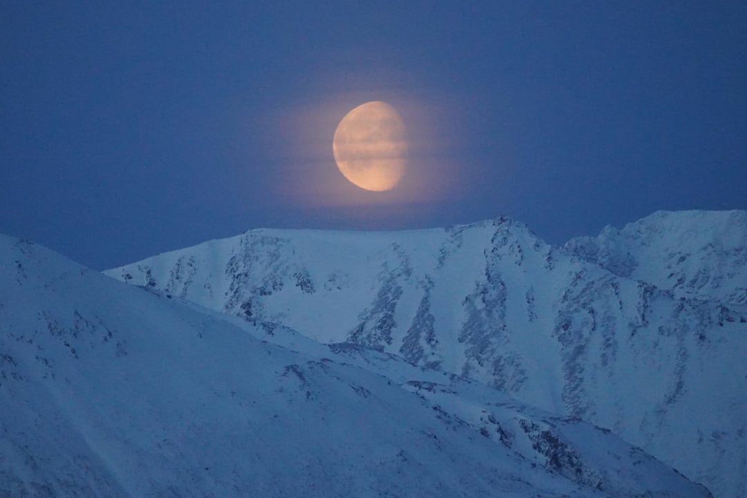 The moon is shining bright over the Lyngen Alps in Tromsø. Even though it is polarnight there is still