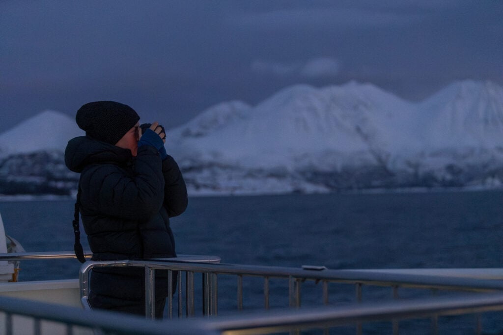 Guest capturing the Arctic landscape during a whale watching tour in Tromsø, Norway