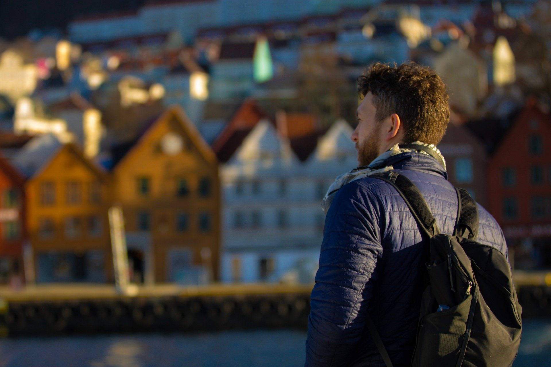 Man looking out over Bryggen in Bergen on a crisp winter day with colorful wooden houses in the background