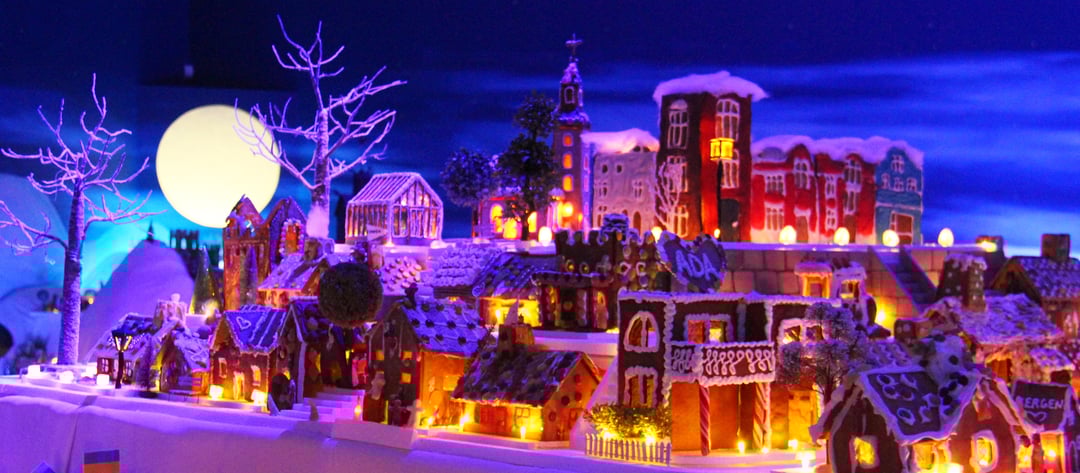 Pepperkakebyen in Bergen illuminated at night with detailed gingerbread houses and winter scenery