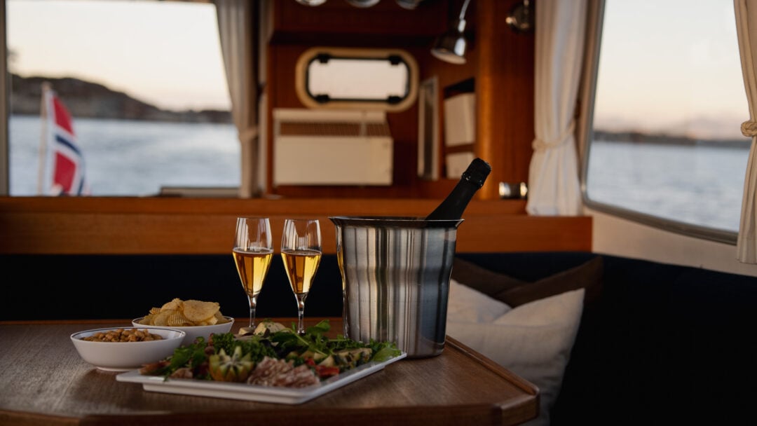 Eksklusiv charterbåt Rygerskyss med servering, champagne og utsikt mot fjorden – privat premium opplevelse på sjøen