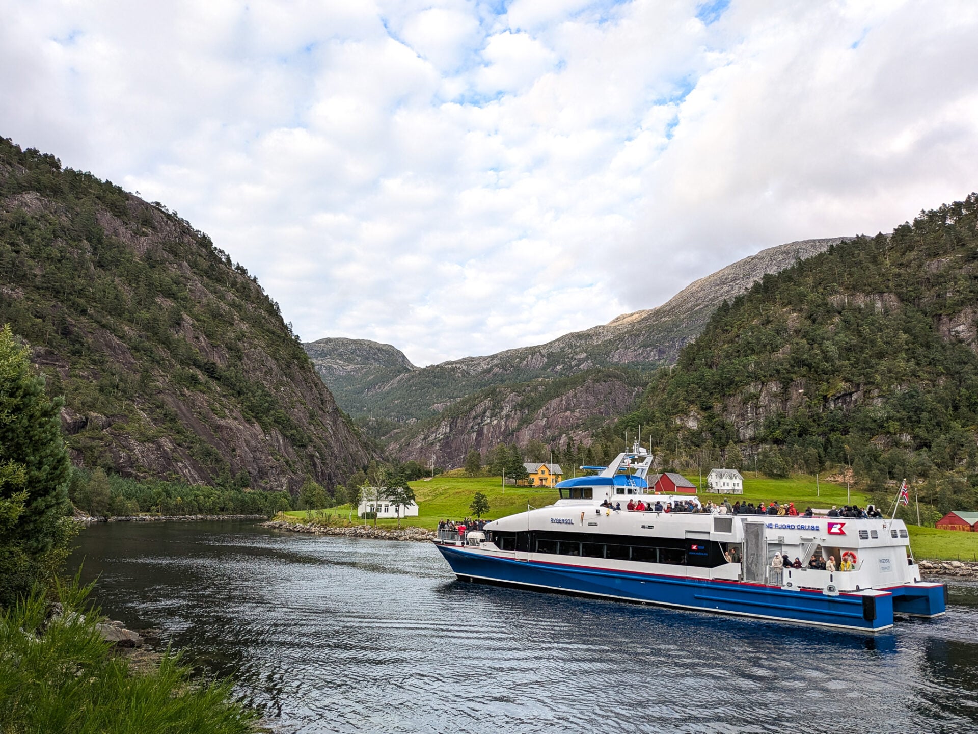 Unser Schiff fährt Richtung Modalen in den Mostraumen ein, umgeben von steilen Bergen und grünen Höfen